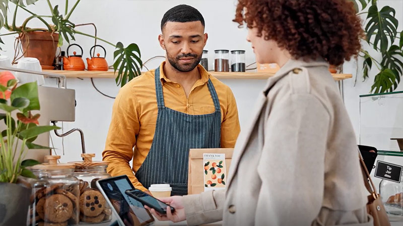 Customer making payments using a mobile phone at a merchant store