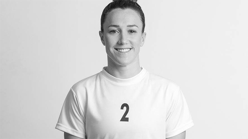 Lucy Bronze smiling at the camera wearing her jersey with the number two on it. 